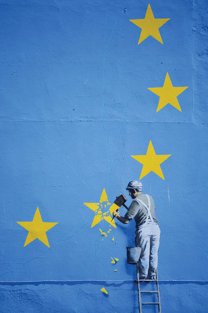 Detail of a Banksy mural about Great Britain leaving the European Union shows a worker chipping one golden star out of a field of blue. (Photo by Ian Clark.)