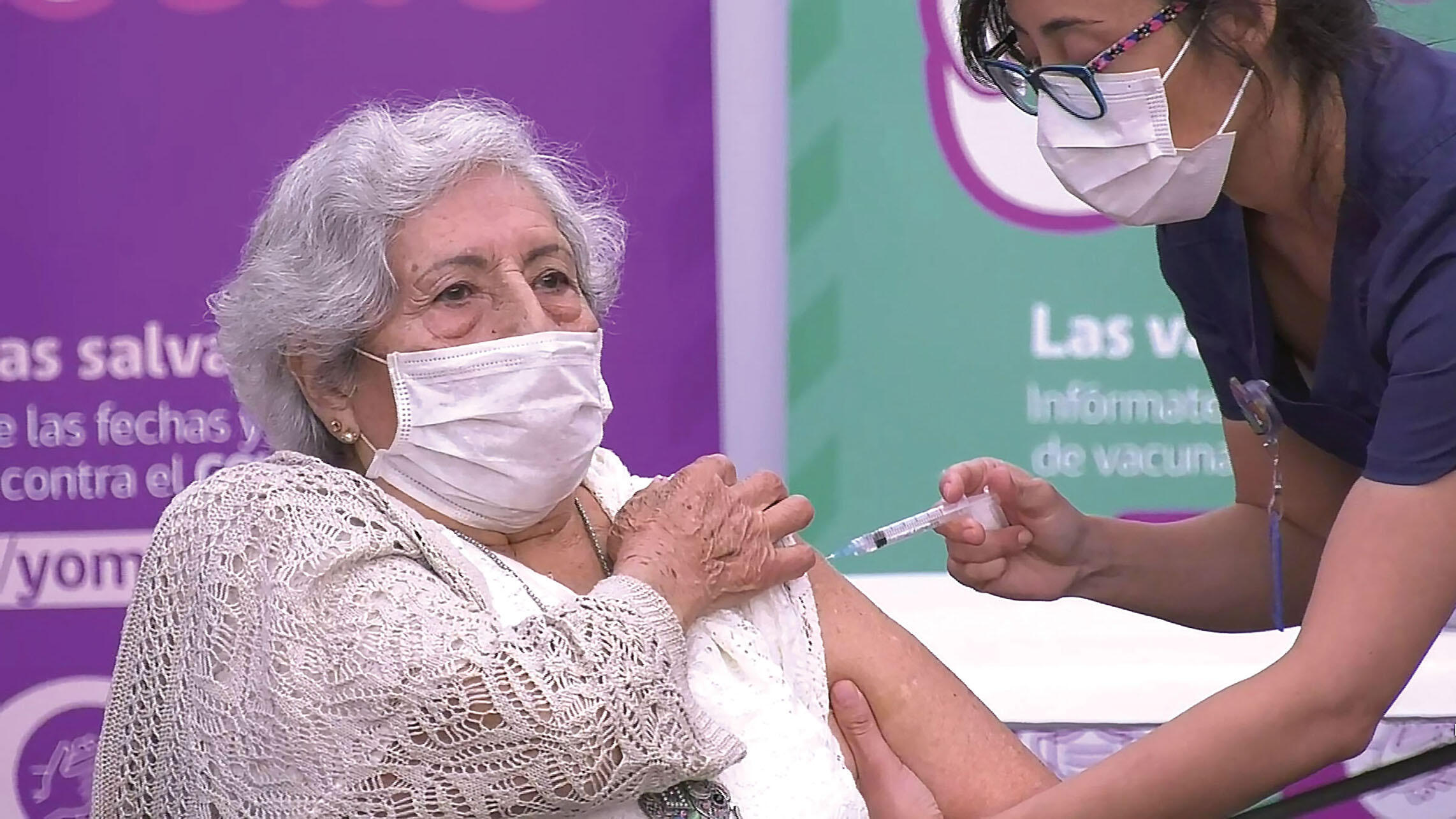 A older woman in a sweater is vaccinated in Santiago, February 2021. (Photo courtesy of Mediabanco Agencia.)