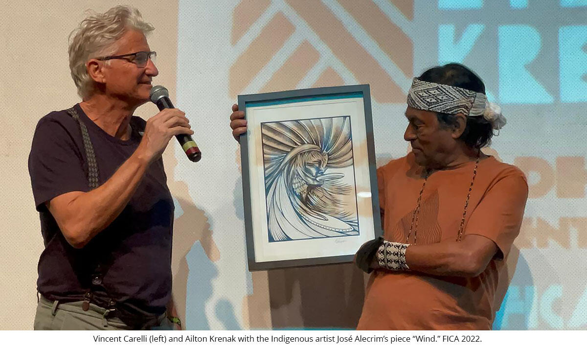 Vincent Carelli (left) and Ailton Krenak with the Indigenous artist José Alecrim’s piece “Wind.” FICA 2022.