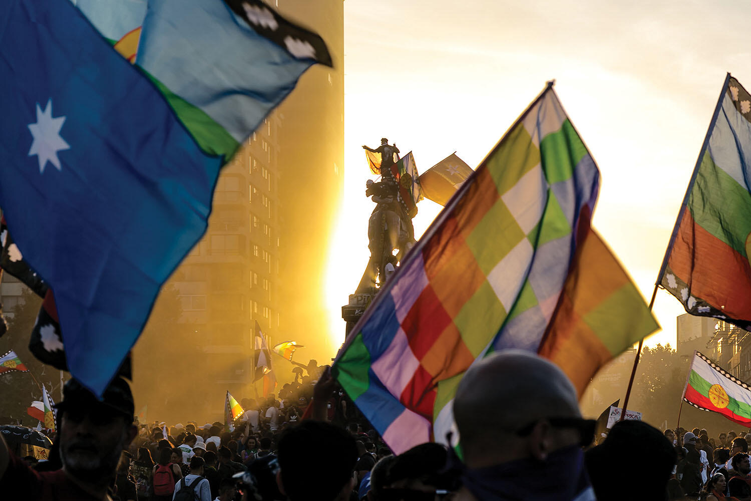 Flags representing Indigenous peoples fly over a protest in Santiago’s Plaza Baquedano, October 2019. (Photo by Matías Garrido Hollstein.)