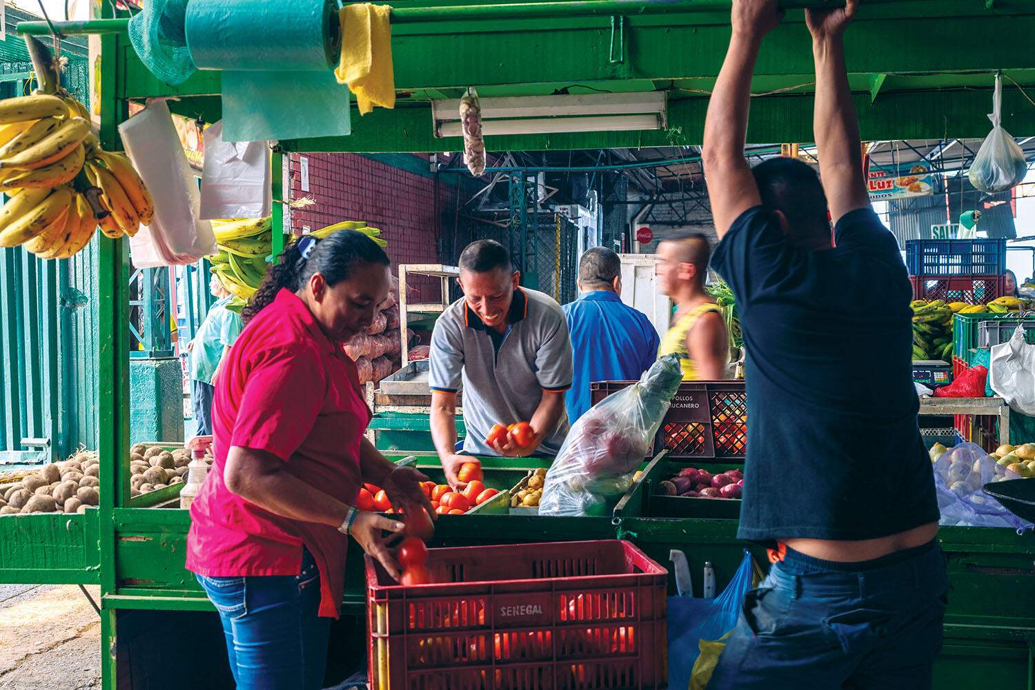 In the foreground from left to right, El Porvenir vendors Yesenia Orrego, James Hernández, and Celso Elvis Ordóñez store produce at day’s end. (Photo by Fabian Villa.)