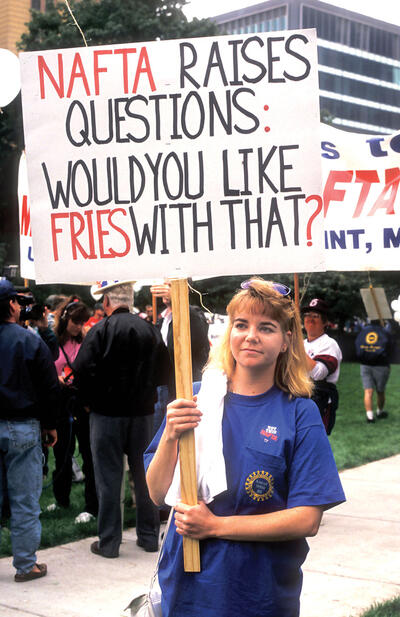A protester with a sign questioning the quality of jobs created under Nafta. (Photo by Jim West/Alamy Stock Photo.)