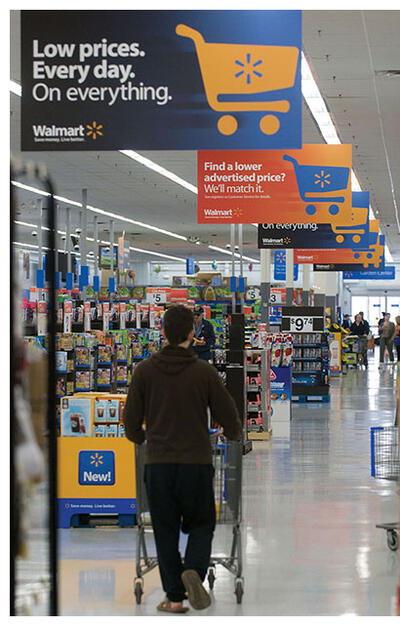 A shopper in the aisle at Walmart, which with other large retailers opted to form a less stringent regime. (Photo courtesy of Walmart Corporation.)