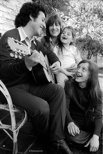Víctor Jara sings with his family. (Photo by Antonio Larrea.) Víctor Jara playing a guitar and singing with his family. (Photo by Antonio Larrea.)