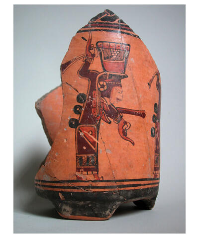 A broken orange and brown pottery urn is decorated with a woman carrying a vessel filled with liquid as part of a ceremony. Ulua Valley, ca. 700-800 CE, from the Museo de San Pedro Sula. (Photo courtesy of Russell Sheptak.)